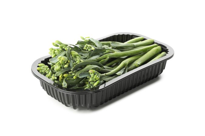 Plastic container with broccolini isolated on plain background