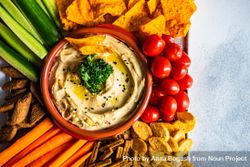 Traditional hummus dish served with cherry tomatoes and chips 0Ldrvr