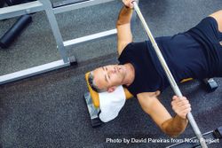 Top view of male lying on bench lifting weights 5rpolb