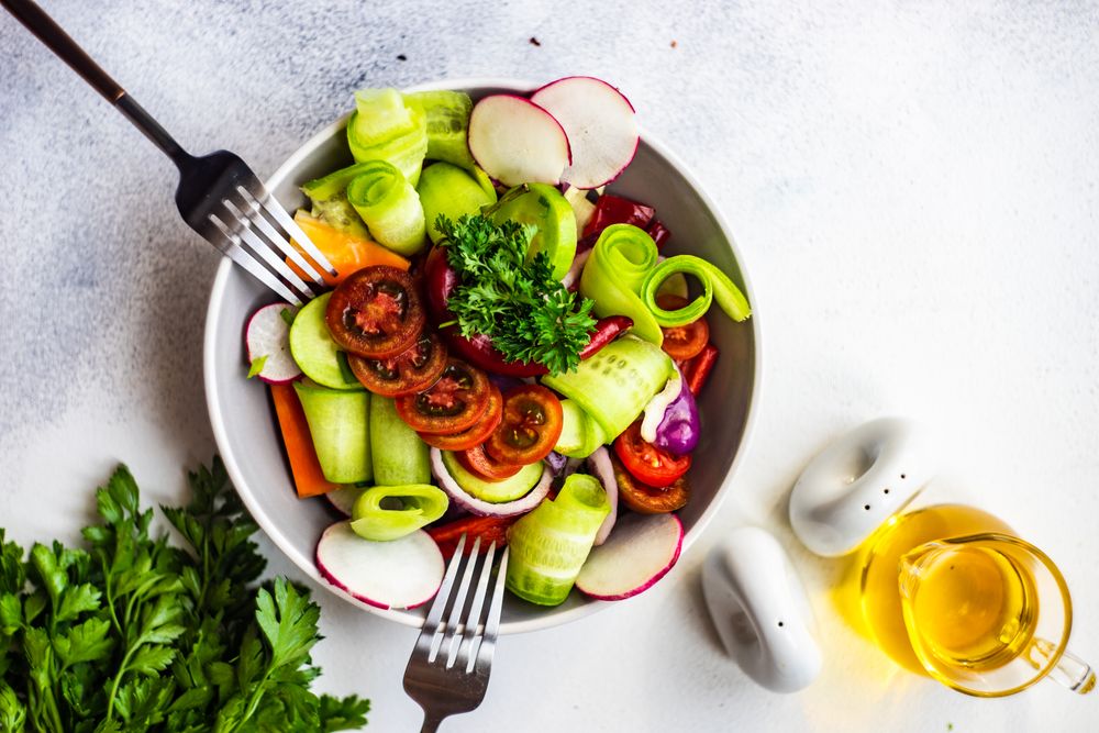 Top view of raw salad with freshly chopped vegetables served with two forks
