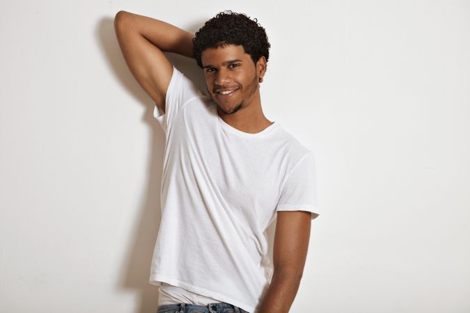 Smiling Black man with arm behind his head in studio shoot