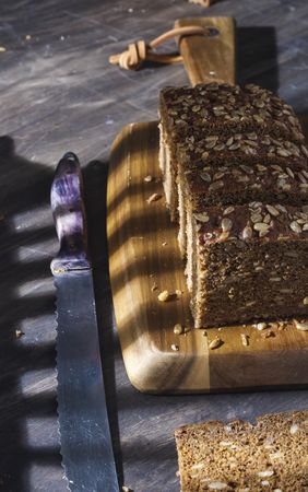 Sliced wholegrain bread on wooden cutting board