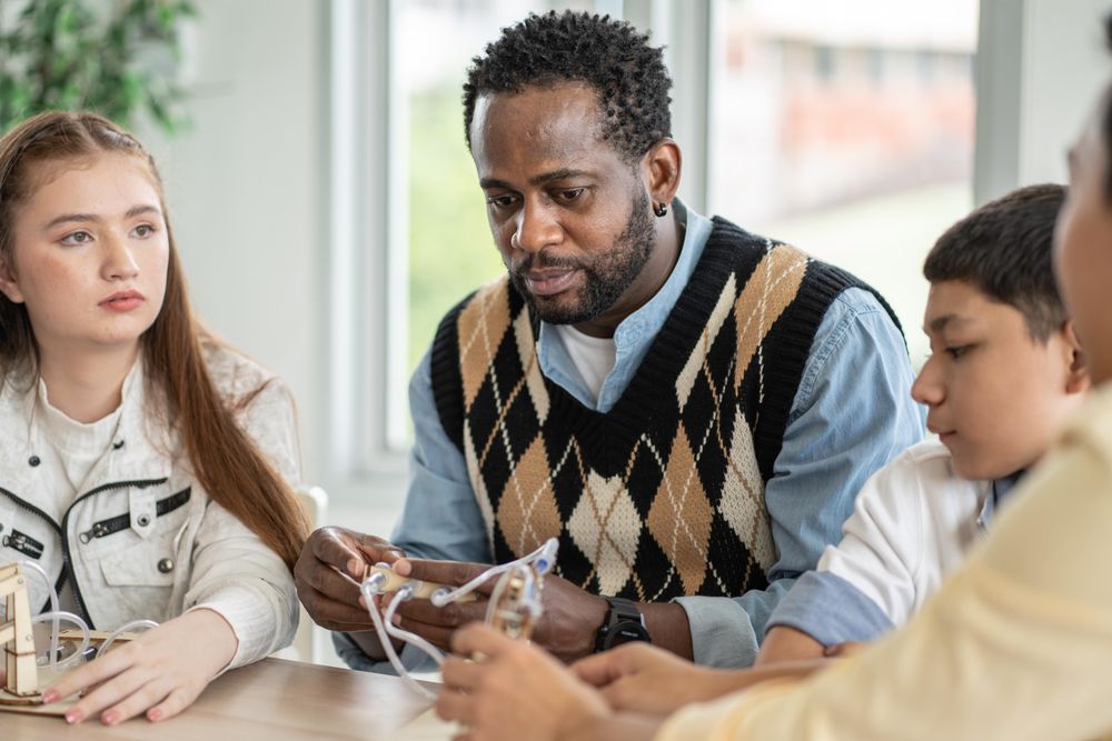 Black male with students in science class