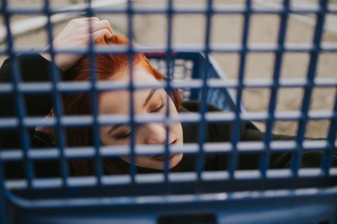 Woman looking through trolley grate in shopping cart