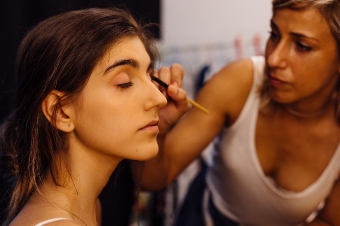 Makeup artist applying eye shadows on model
