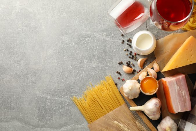 Composition with pasta and ingredients for cooking on gray background