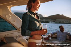 Happy woman wearing bikini bottoms and denim top while hanging out on boat 43ejj0