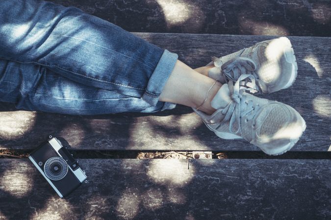Woman sitting on bench with crossed legs