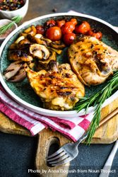 Plate of grilled chicken with tomatoes and mushroom on counter 49mNam