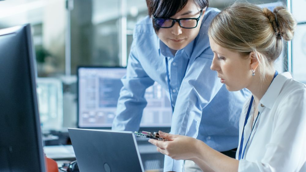Female Computer Scientists Connects Circuit Board to Her Laptop and Starts Programming it.