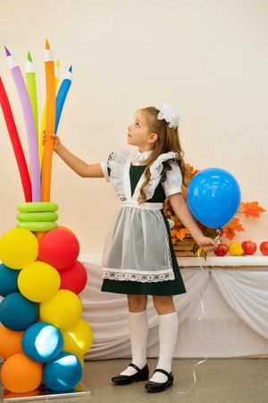 Full-length portrait attractive little schoolgirl in uniform hold balloon