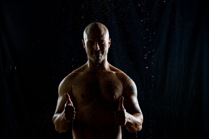Cheerful bald man under rain