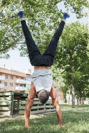 Sportsman standing on hands in park