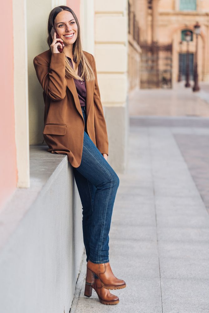 Pleased female in stylish outfit on street smiling away