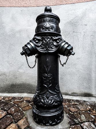 Old fire hydrant, water column on the street in Sion