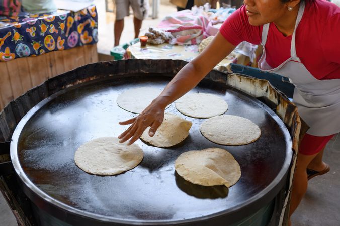 Woman cooking delicious corn tortillas