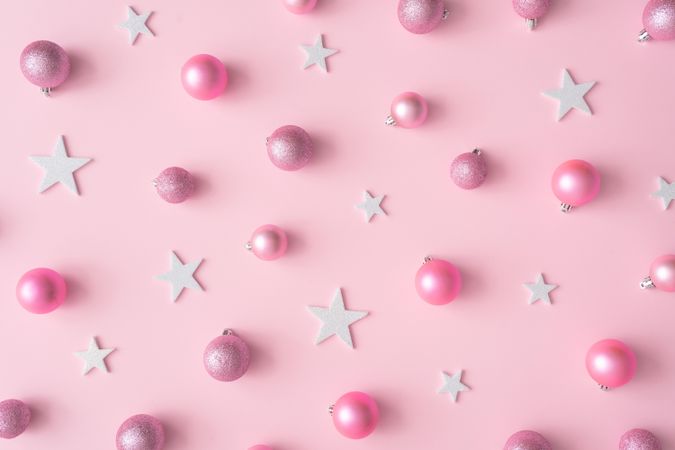 Different shades of pink baubles and star decorations on a pink background