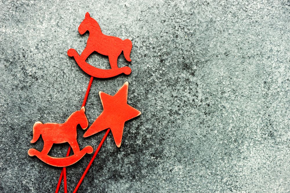 Three red wooden ornaments on grey background