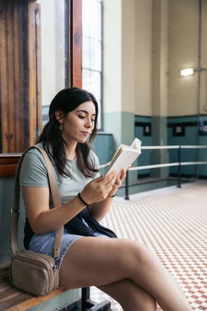 Woman reading a book sitting on a bench