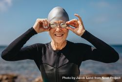 Portrait of a smiling older female swimmer with sea in the background 0y6JW5