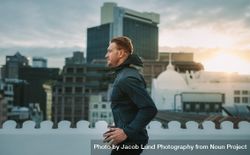 Fitness man doing exercises on the terrace of a building with sunrise in the background 416WZb