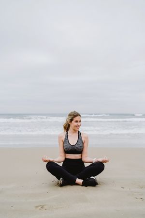 Woman meditating on the beach