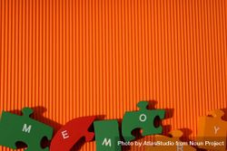 Orange paper background with puzzle pieces spelling out the word “Memory” 48YJKb