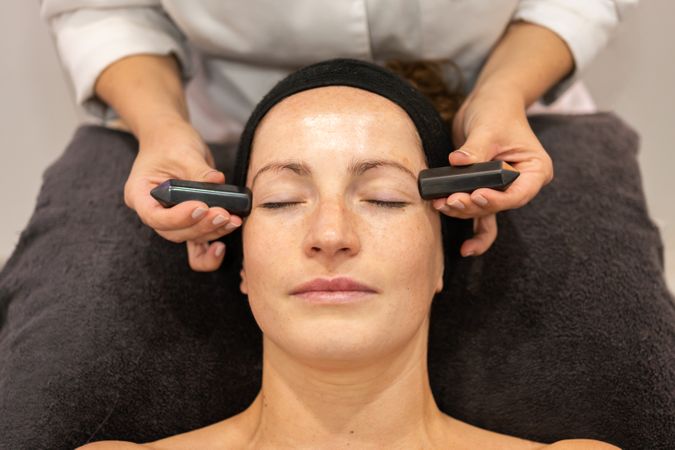 Woman having relaxing facial with temple massage