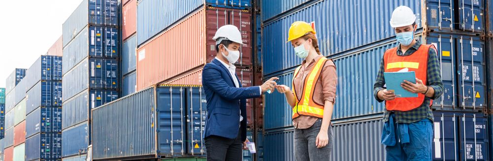Logistic warehouse foreman giving alcohol gel onsite to worker, banner