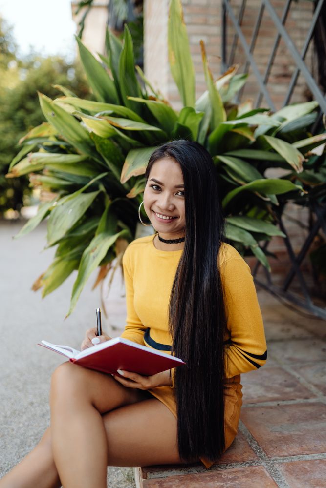 Asian woman reading book on the street