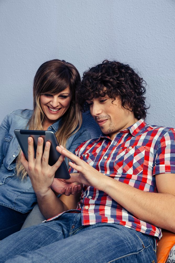 Couple looking at the tablet together in bed