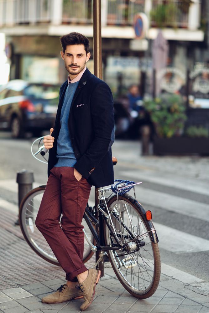 Man standing on the street wearing elegant suit with a parked vintage bicycle