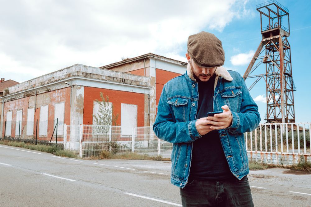 Man using smartphone outside industrial building