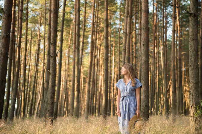 Smiling young woman relaxing among pine trees