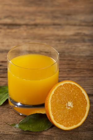 Glass with orange juice on the table.
