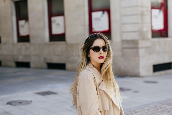 Young woman in sunglasses posing on street