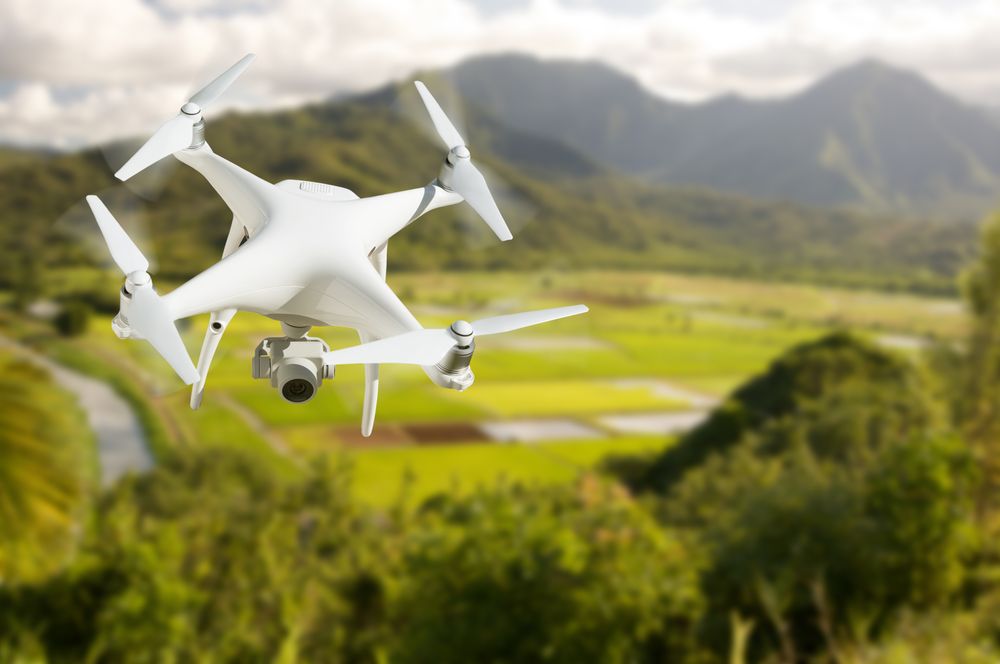 Unmanned Aircraft System (UAV) Quadcopter Drone In The Air Over Hanalei Valley and Taro Farm Fields on Kauai, Hawaii.