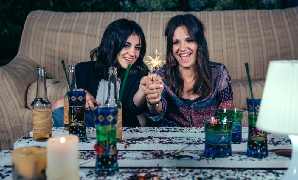 Laughing women holding sparklers in a party