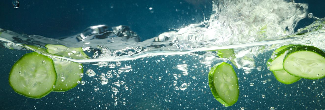 Wave of water with cucumber slices, banner