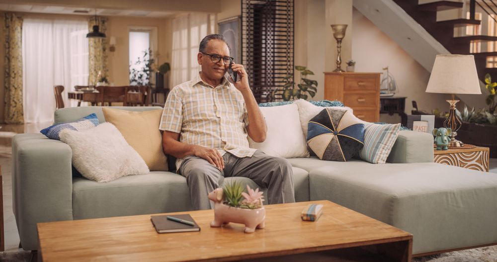 Portrait of Older Indian Man Using Smartphone, Calling His Friends from Home.