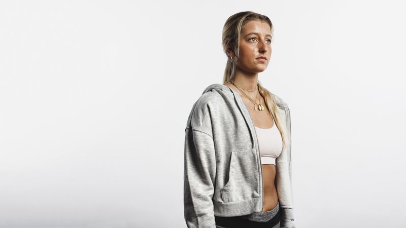 Portrait of fitness woman standing against neutral background