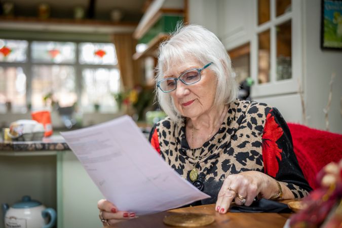 Woman reading papers at breakfast table