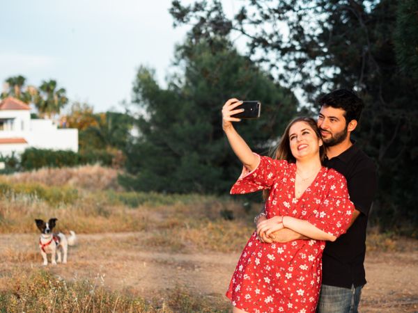 Couple kissing and taking photo outdoors