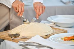 Unrecognizable chef serving fish baked in salt crust