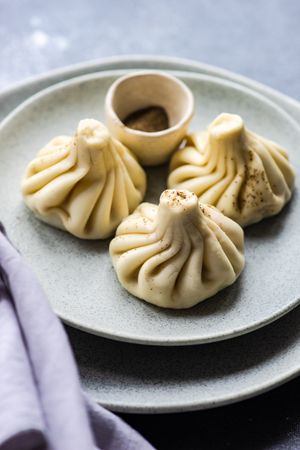 Grey plate with three Georgian khinkali dumplings