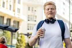 Young Latino man with albinism walking down the city street