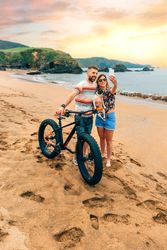 Male and female taking picture with phone standing with bicycle and dog, vertical