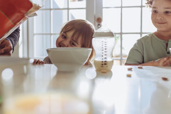 Two children sitting at the breakfast table to drink milk