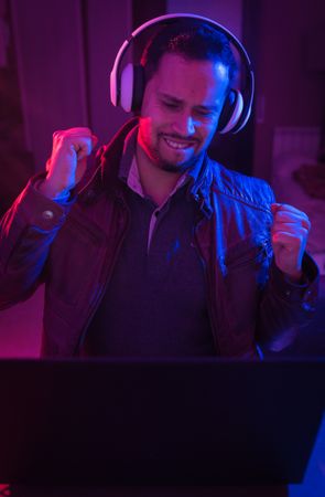 Man listening cheerfully to music with headphones.