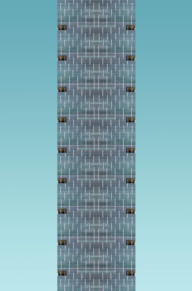 Tall patterned grey building against a blue sky